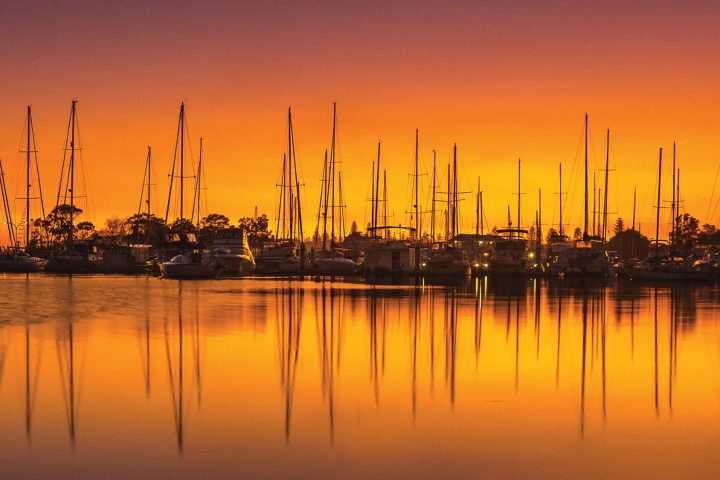 Docked boats in Yamba against a sunrise background