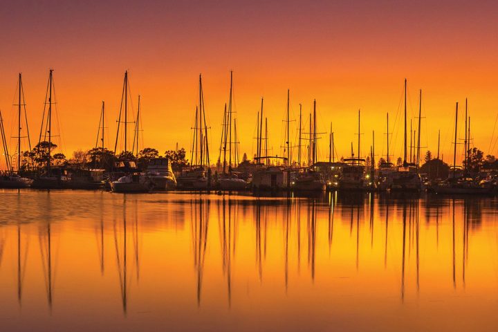 Docked boats in Yamba against a sunrise background